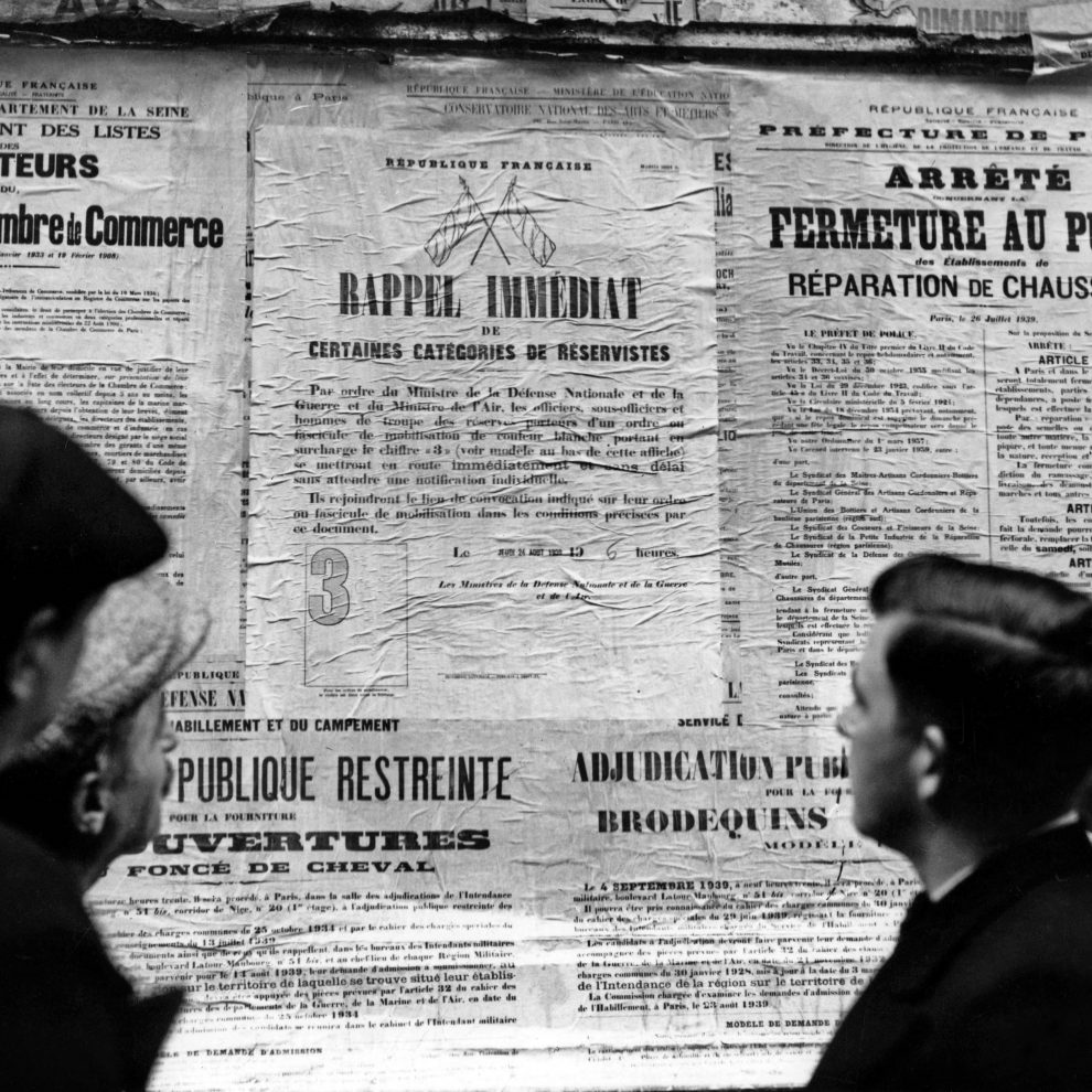 Passants devant les affiches du 24 août 1939 appelant à la mobilisation (rappel immédiat de certaines catégories de réservistes) Paris, France, août 1939.